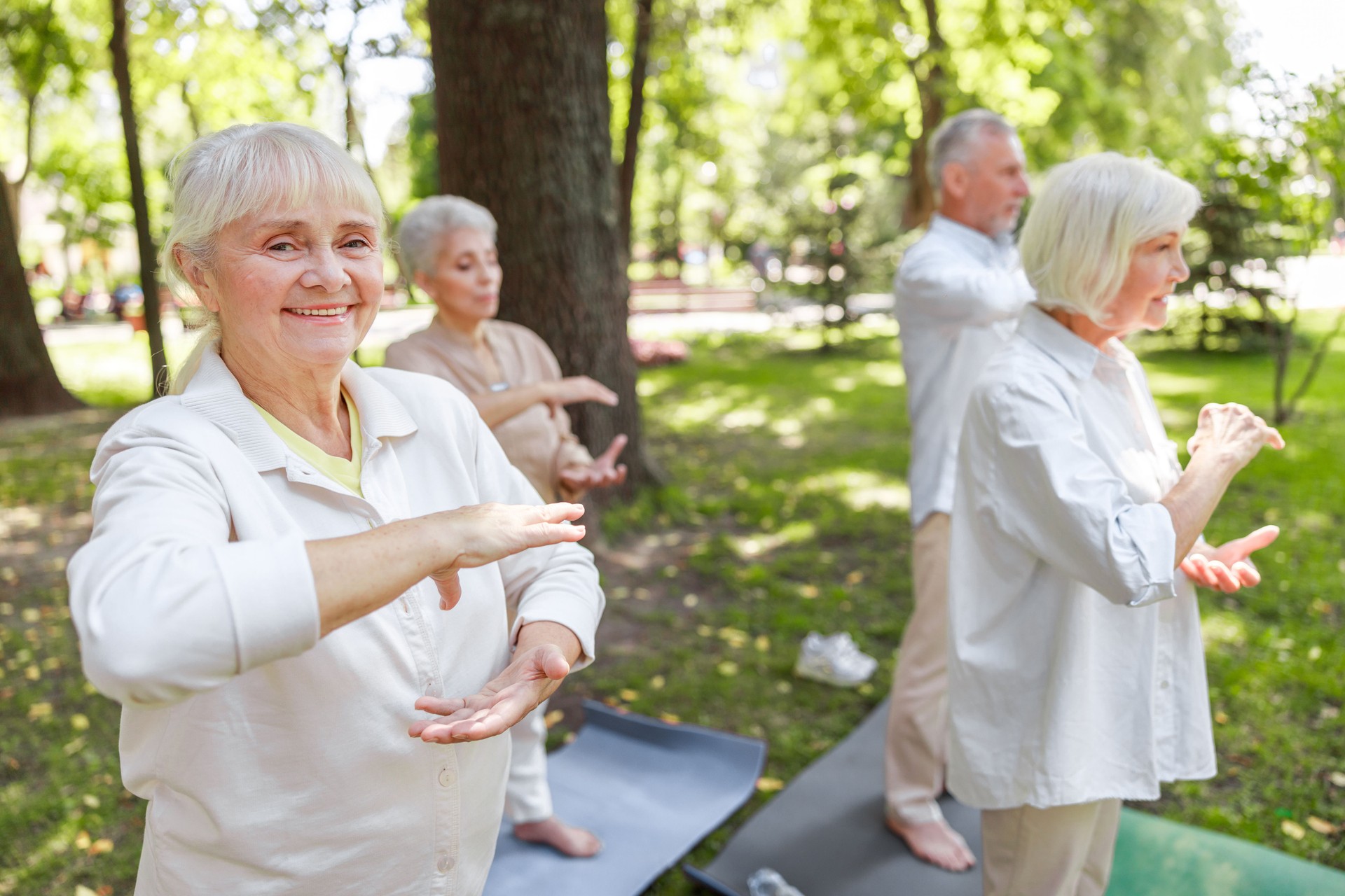 Smiling old lady visiting qigong class in the park