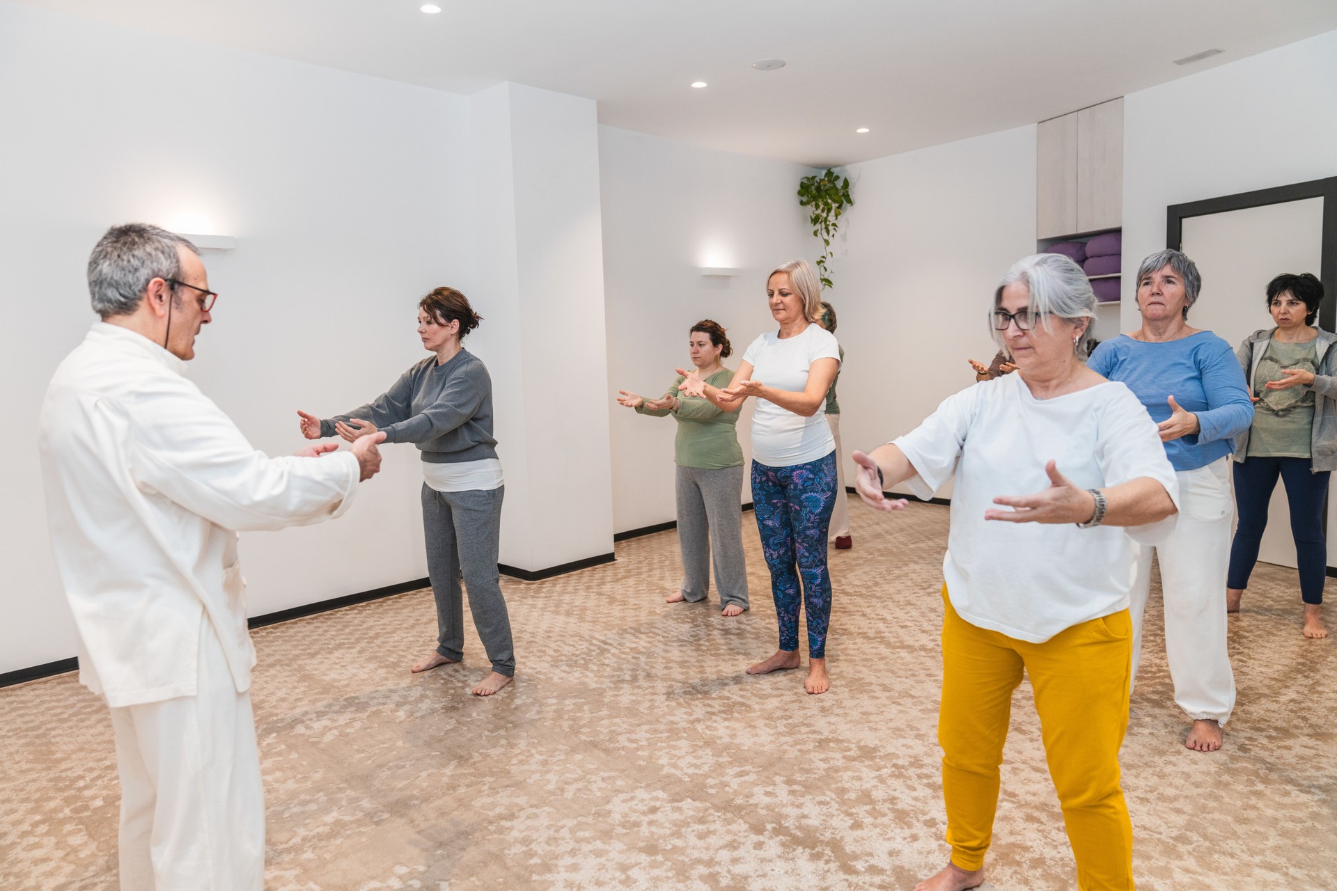 A group of people are practicing Tai Chi in a room