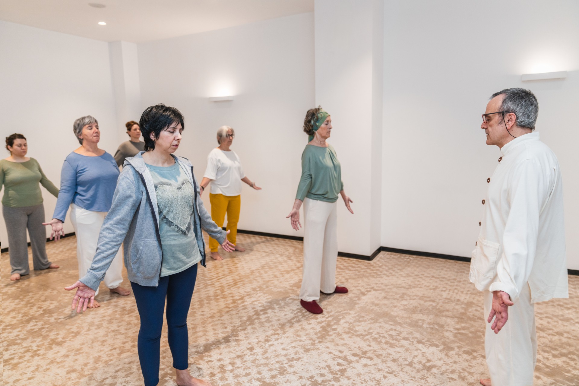 Senior women practicing standing poses in a yoga class led by an experienced instructor